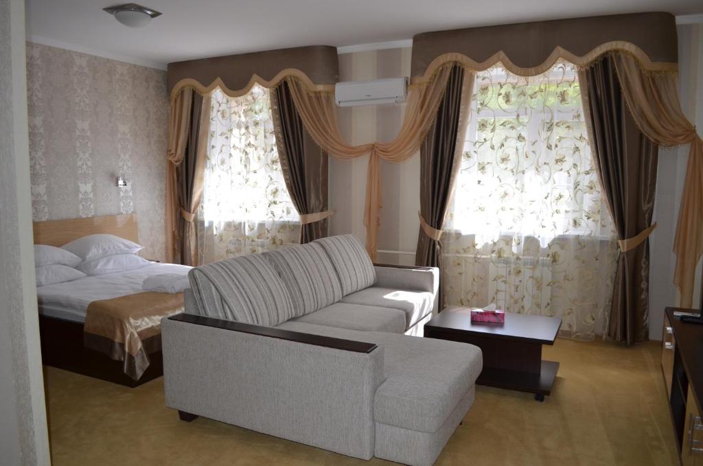 乌斯季卡缅诺戈尔斯克梅来克酒店的客厅配有沙发和1张床