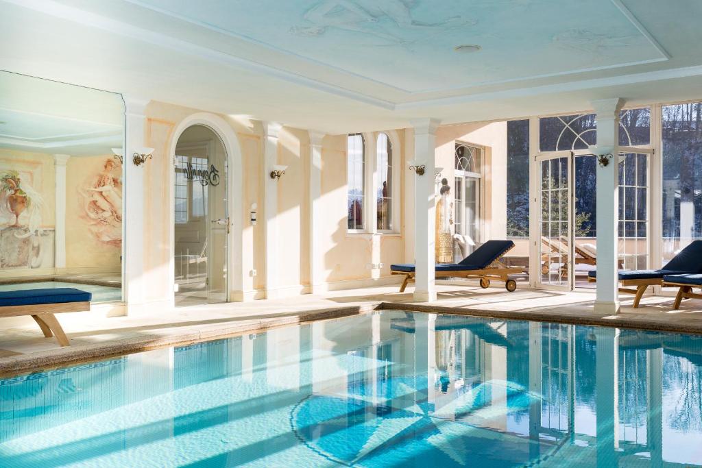 DafinsBoutiquehotel Bergvilla的游泳池位于带椅子的房间,大楼