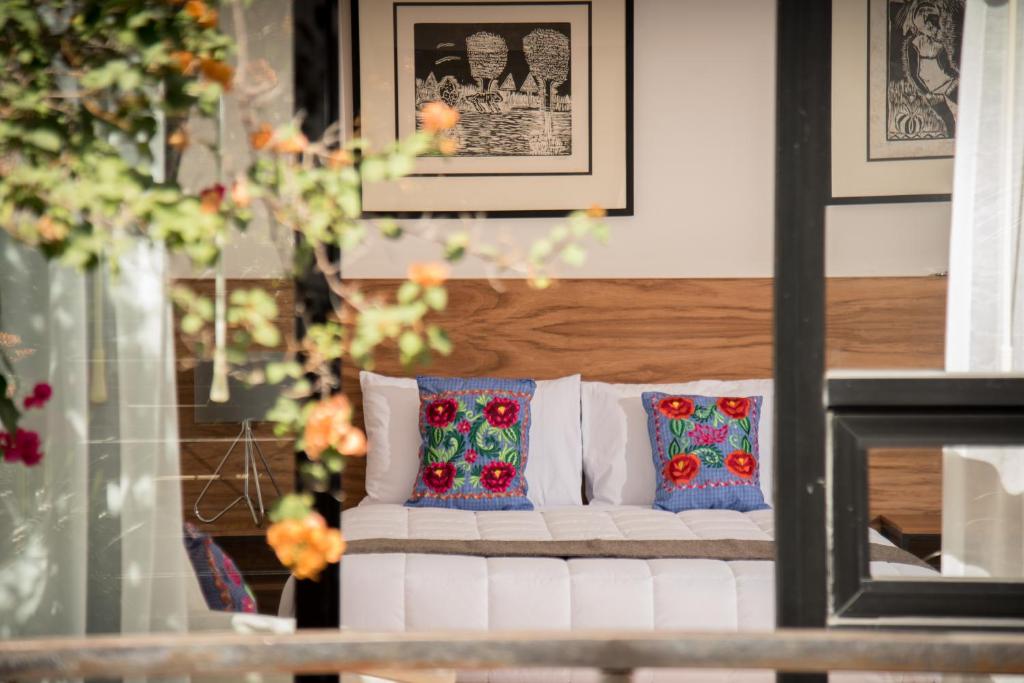 瓦哈卡市Nardazul "Casa de Sueños"的客房内的白色沙发,配有色彩缤纷的枕头