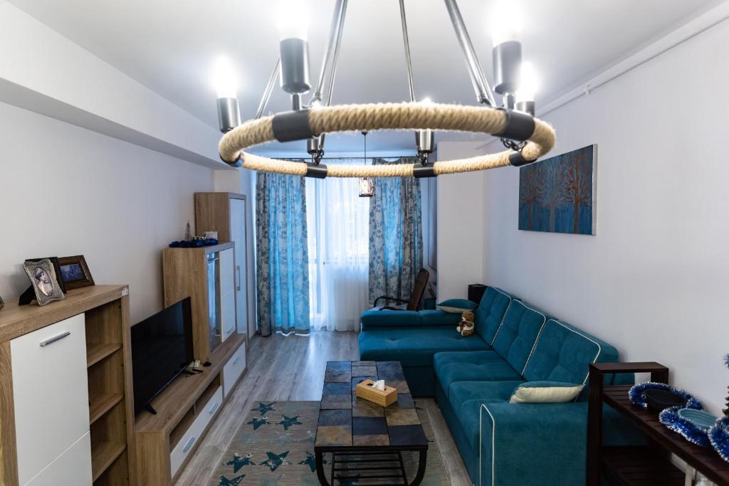 锡纳亚Blue SKY Resort Colina Marei的客厅配有蓝色的沙发和吊灯。