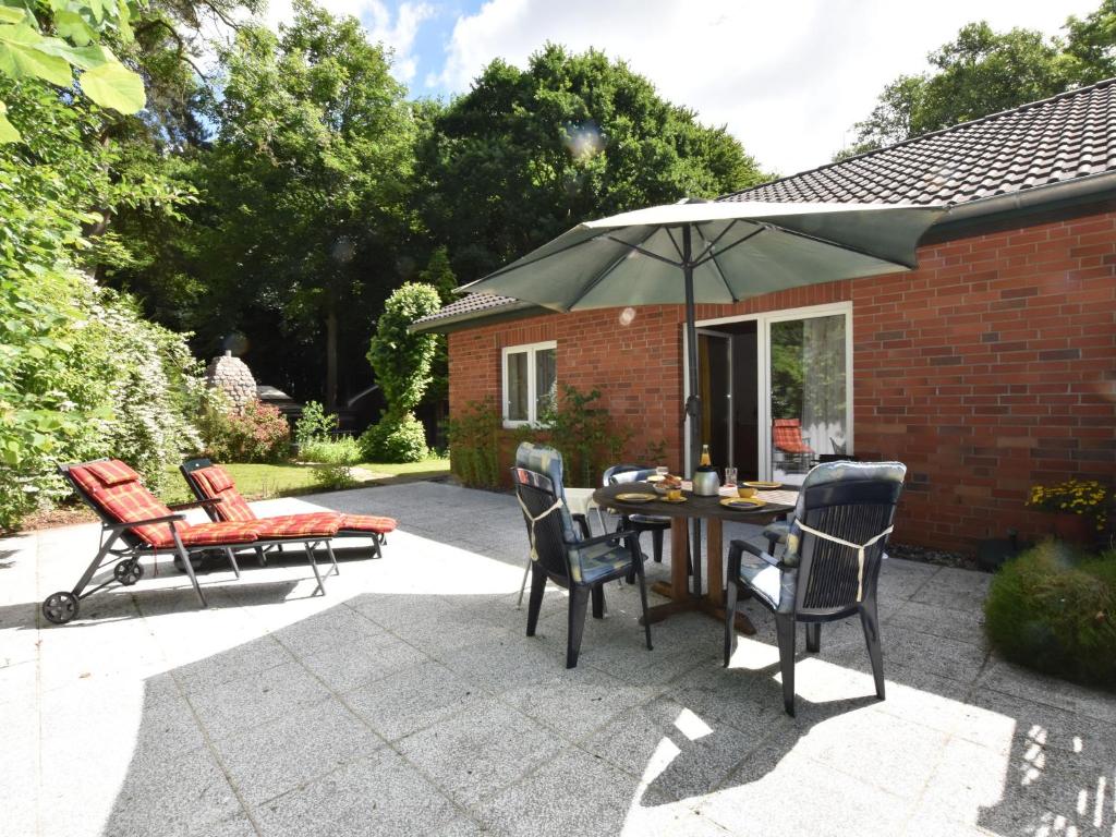 克吕茨Farm holiday home in Damshagen with garden seating and sauna的庭院配有桌椅和遮阳伞。