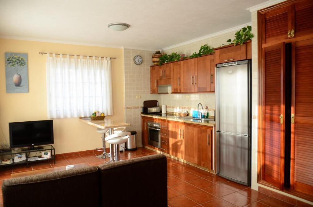 巴耶格兰雷伊Casa Maestro Agustín Nº 1的厨房配有木制橱柜和不锈钢冰箱。