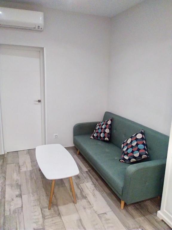 马德里Apartamento estilo nórdico en Malasaña (Madrid Centro)的客厅里有一张绿色的沙发和一张桌子