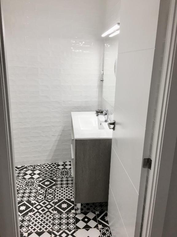 马德里Apartamento estilo nórdico en Malasaña (Madrid Centro)的浴室设有水槽,铺有黑白瓷砖地板。