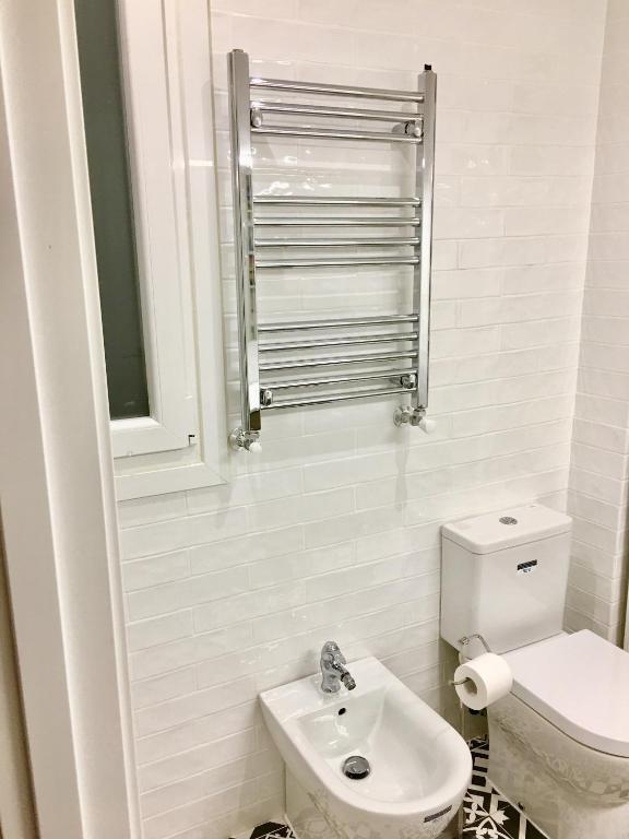 马德里Apartamento estilo nórdico en Malasaña (Madrid Centro)的带马桶和水槽的白色浴室