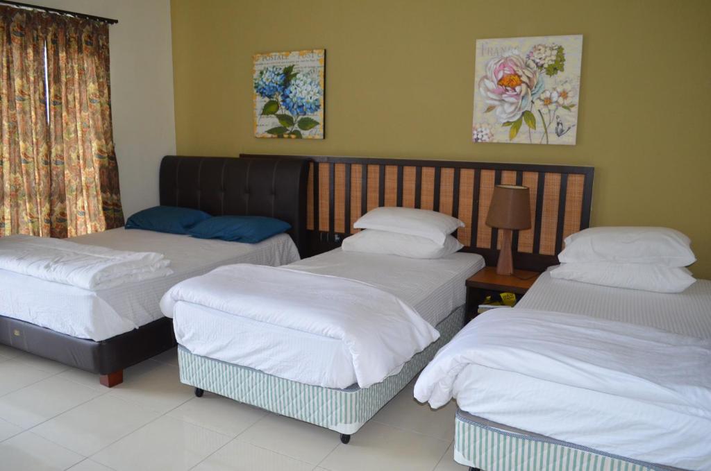 Kampong Tanjong PechahGold Coast Morib Ain Studio的带三张床的客房,位于带窗户的房间内