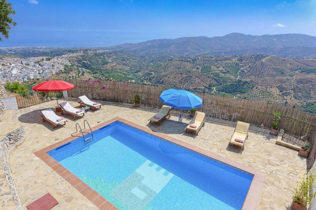 弗里希利亚纳Villa Lizar的一个带椅子和遮阳伞的游泳池,享有美景