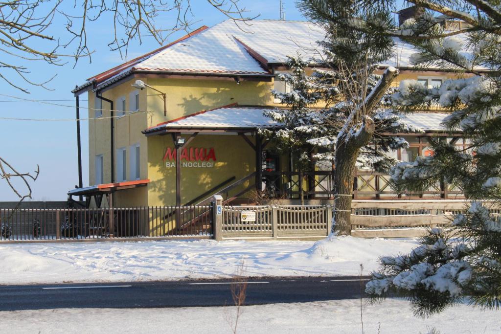 罗兹地区亚历山德鲁夫Bar Malwa的雪中带围栏的黄色房子