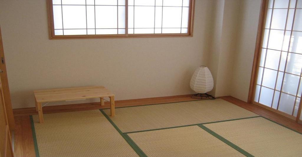 京都Guesthouse Hyakumanben Cross japanese room / Vacation STAY 15396的一间房间,地板上设有一张桌子和一个花瓶
