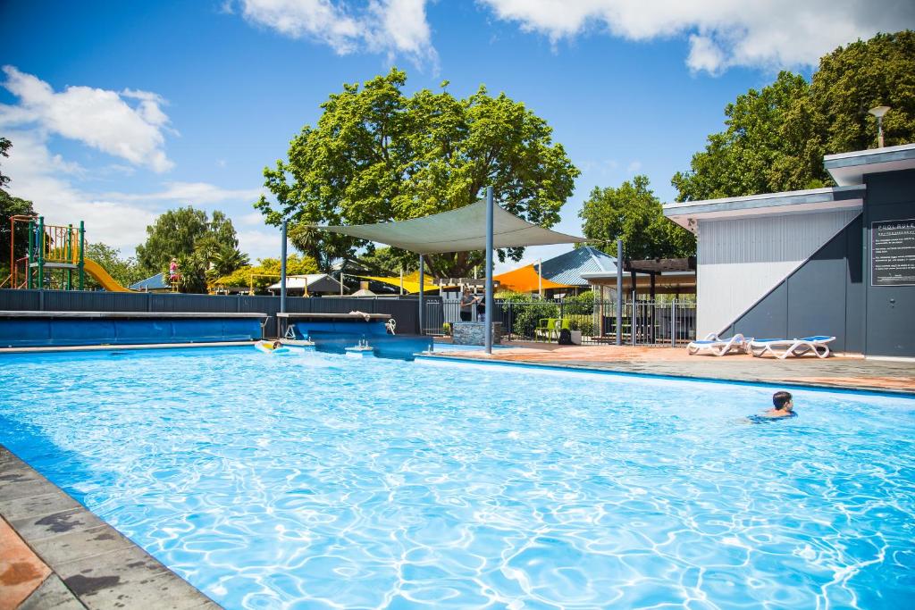 哈士汀黑斯廷斯十佳假日公园酒店的在大型游泳池游泳的人