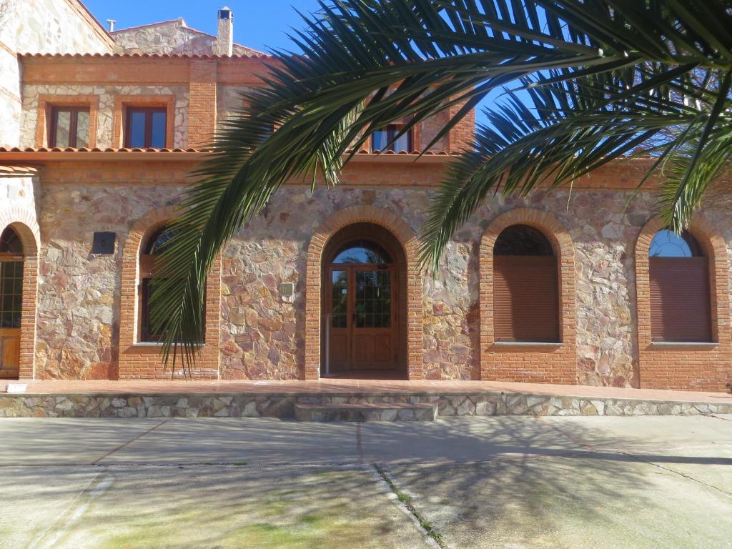 Valencia de las Torres坎波比尔托青年旅馆的前面有棕榈树的房子