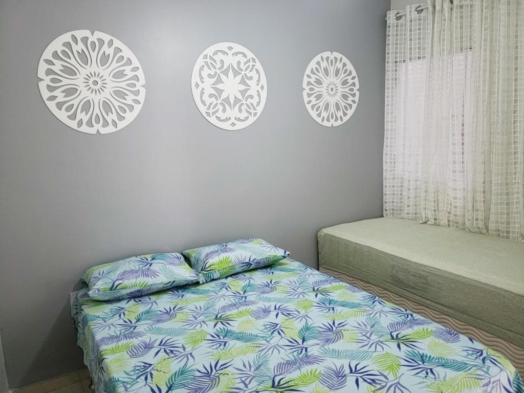 卡波布里奥卡布弗里乌度假屋的卧室配有一张床,墙上挂着三个盘子
