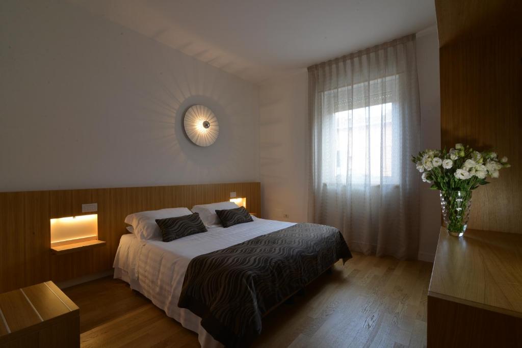 马泰拉圣多梅尼科艺术酒店的一间卧室,配有一张床和花瓶