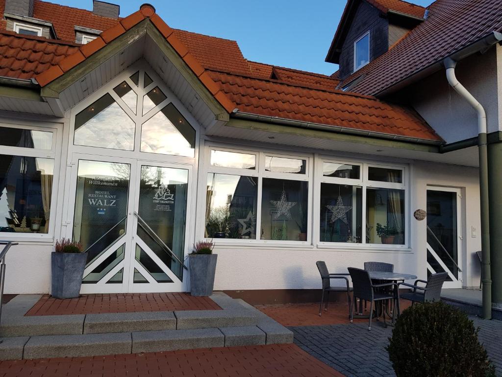 Salzkotten瓦尔茨酒店的一座带窗户和桌椅的建筑