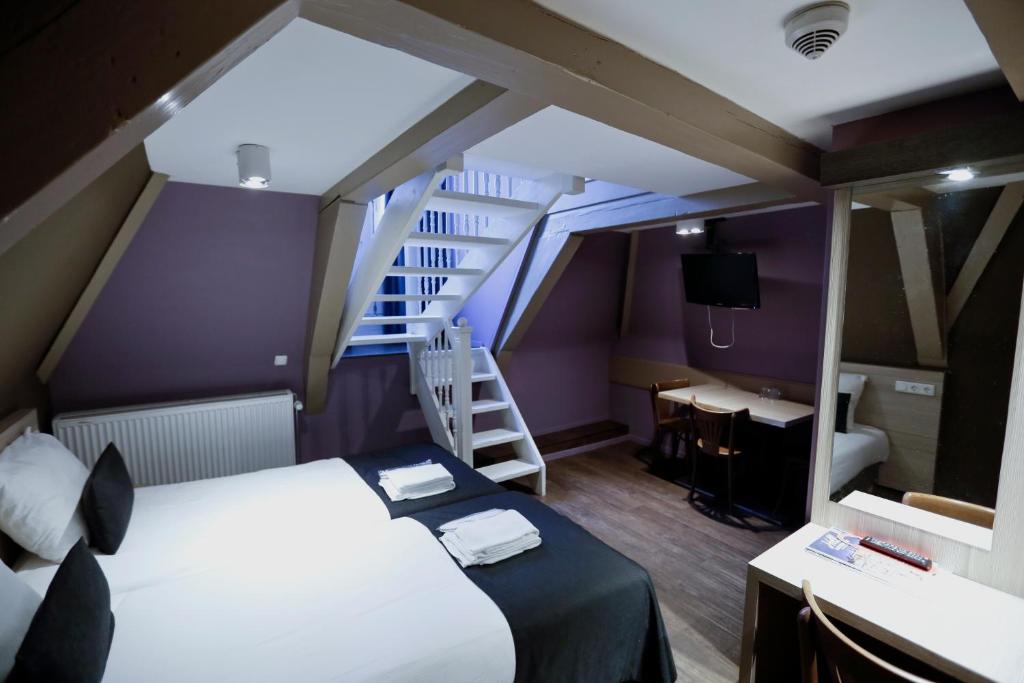 阿姆斯特丹阿姆斯特丹城市酒店的小房间设有床和楼梯