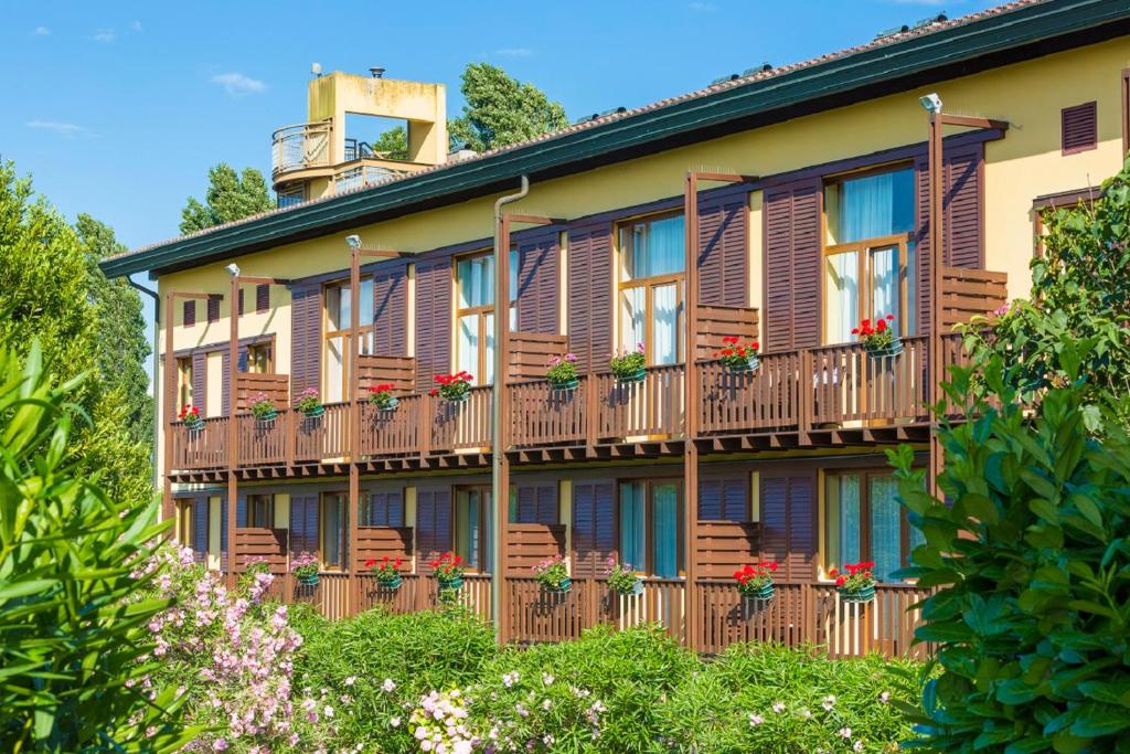 利尼亚诺萨比亚多罗Hotel Golf Inn的公寓大楼设有木制阳台和花盒