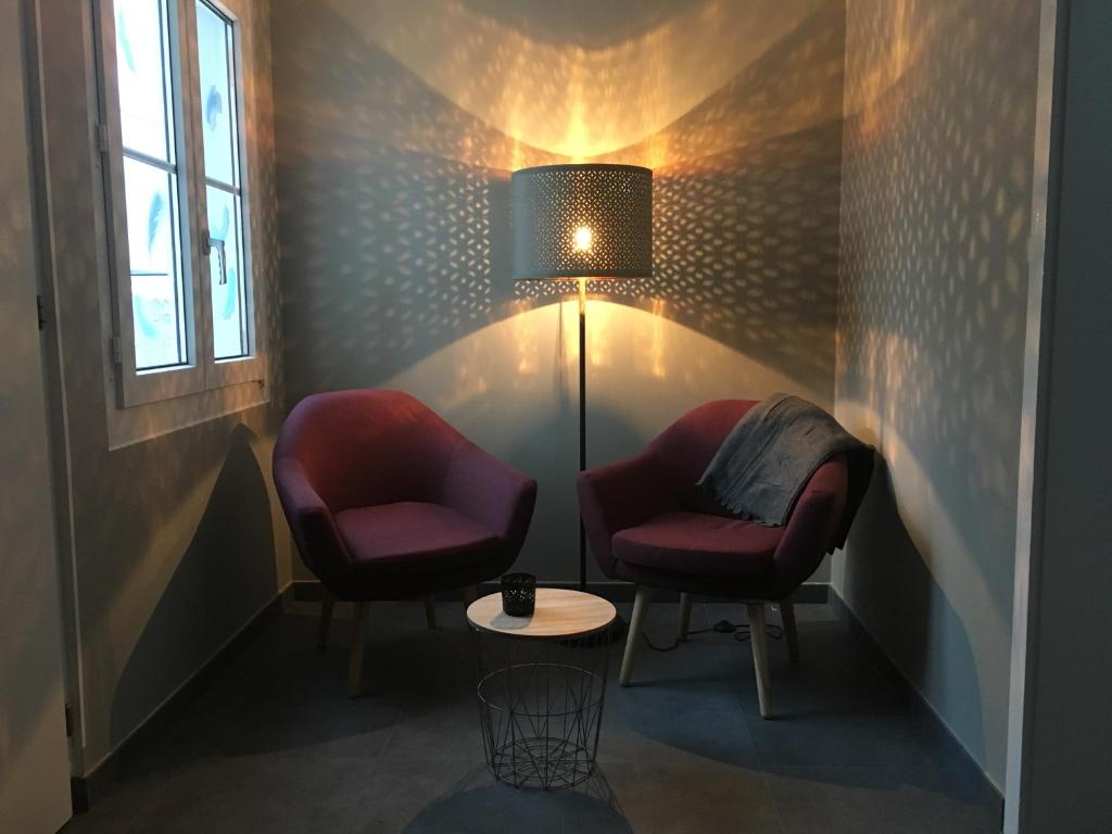 HauteriveBleu Bambou的两把椅子和一张桌子,位于带灯的房间