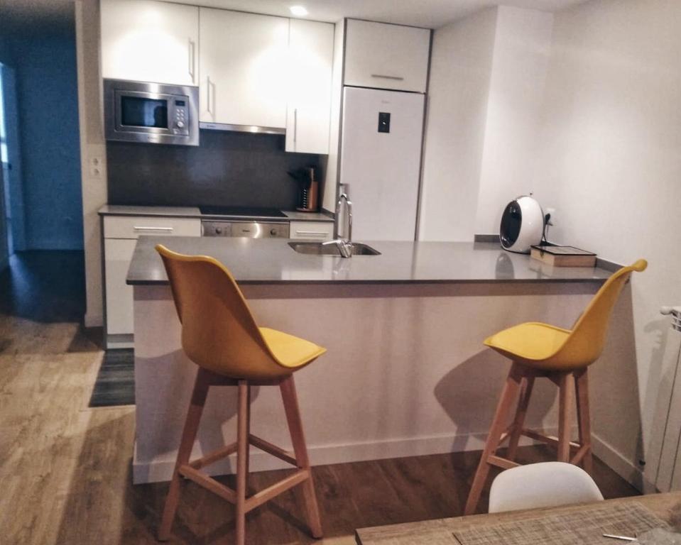 阿斯佩蒂亚Apartamento Erdi Kale的厨房配有2把黄色椅子和台面