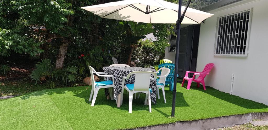 萨拉济Villa Azalées的草坪上的桌椅和雨伞