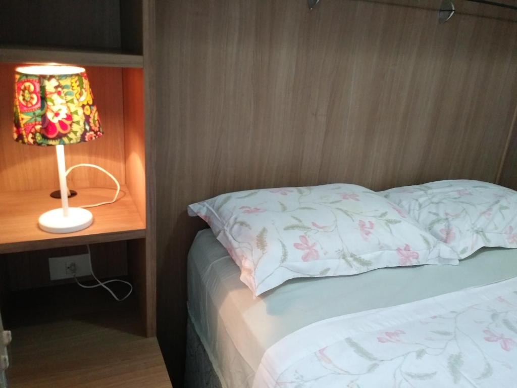马瑙斯Ajuricaba Suites 6的卧室配有带灯的卧室,毗邻床 ⁇ 