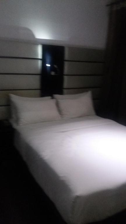 勒莫尔尼JN Sunflower的一张带白色床单和枕头的床