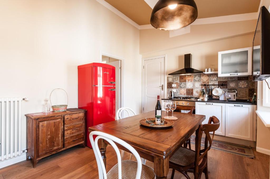 卢卡Affordable suite with a view in the Heart of Lucca的厨房配有木桌和红色冰箱。