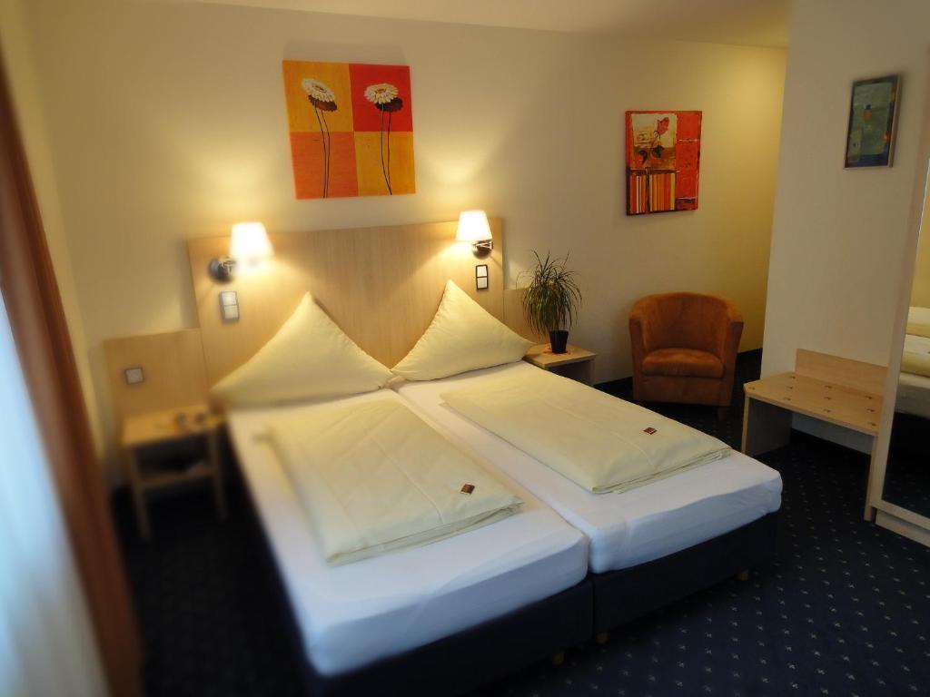 Großostheim兰德加斯托福霍克旅馆的酒店客房带一张大床和一把椅子