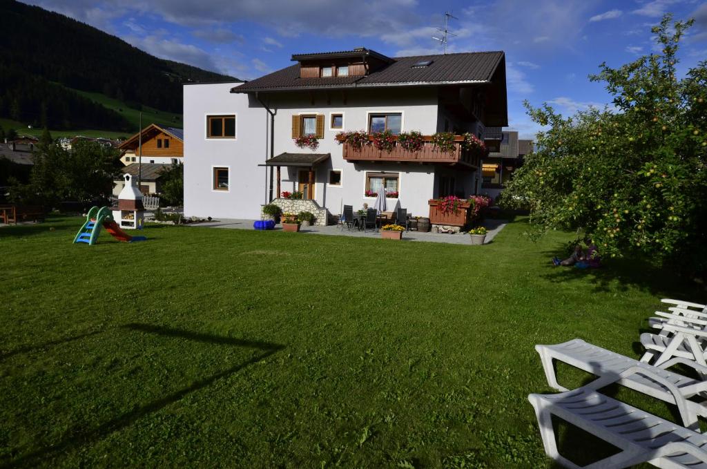 维拉巴萨Haus Cosso的白色的房子,带草坪椅的院子