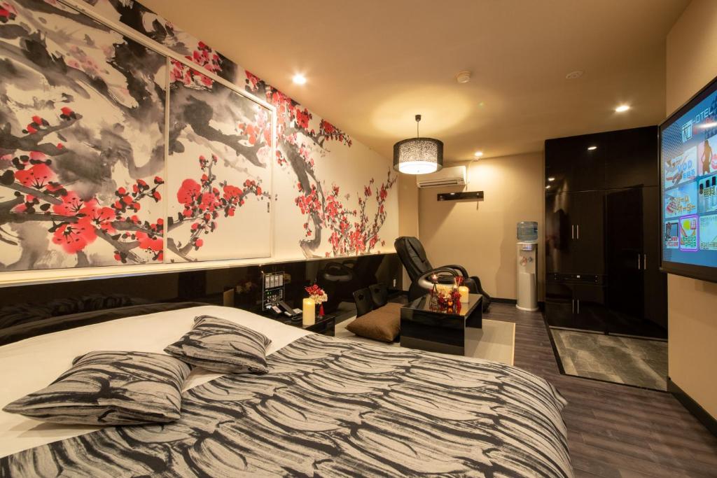 涩川市Hotel Waraku Shibukawa的一间带大床和电视的卧室