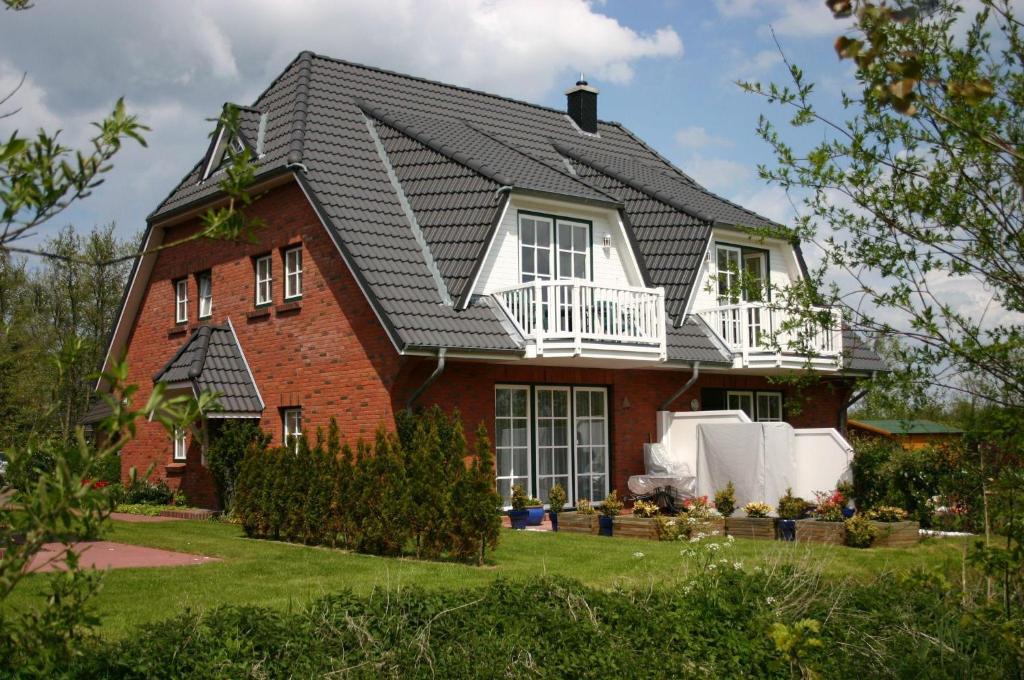 南赫夫特Gaestehaeuser-Heidehof-Wohnung-1的黑色屋顶红砖房子