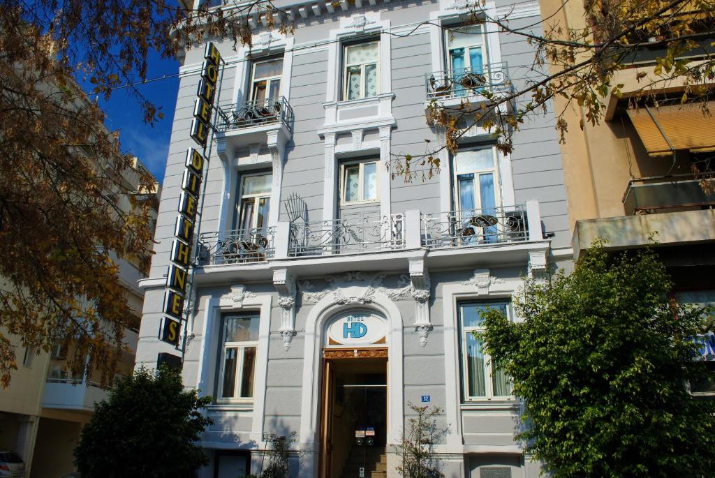 雅典迪尔特尼斯酒店的一座大型白色建筑,设有门和阳台