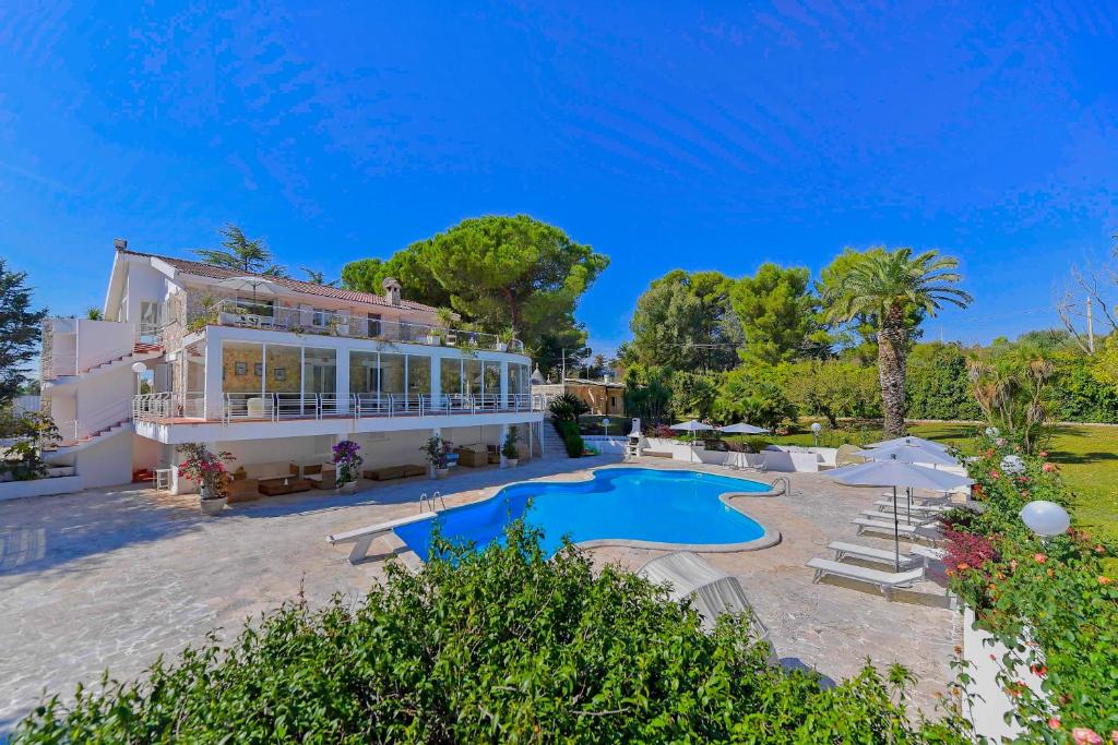 马丁纳弗兰卡Villa del Sole Martina Franca的一座大房子,前面设有一个游泳池
