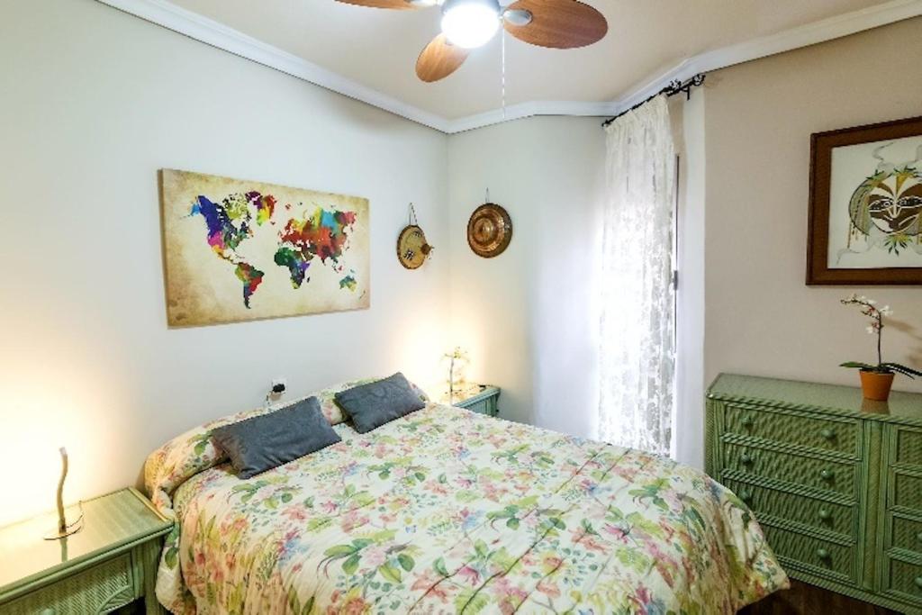 科尔多瓦Apartamento Azahara的一间卧室配有一张床和吊扇
