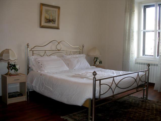 的里雅斯特AL PONTEROSSO的卧室配有白色的床和窗户。