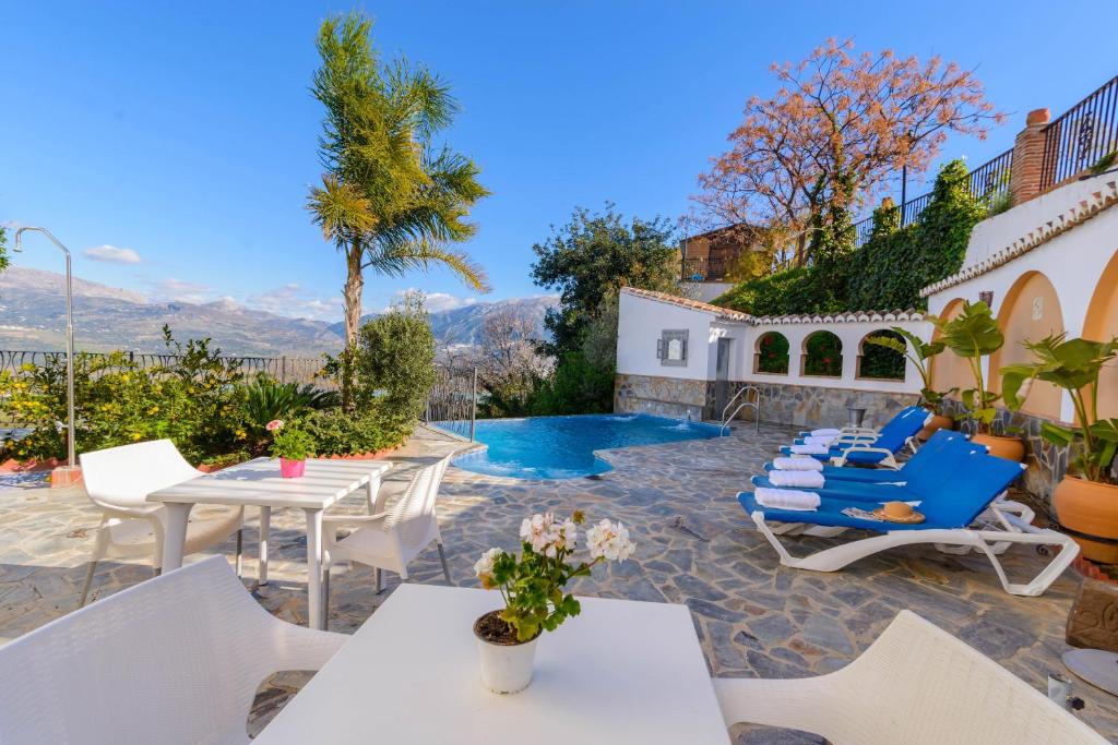 Los Romanes西班牙拉斯奥奎迪斯酒店的一个带桌椅的庭院和一个游泳池