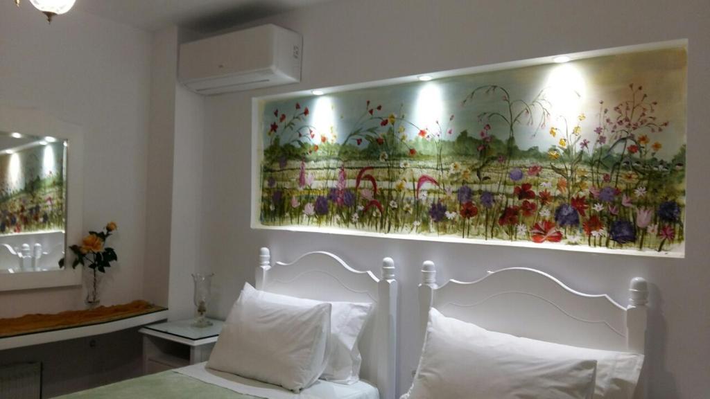 斯巴达NN Luxury Room near Athens Airport的卧室配有床上方的花画