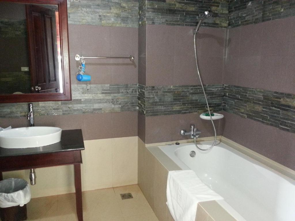 Muang Không庞恩竞技场酒店的带浴缸和盥洗盆的浴室