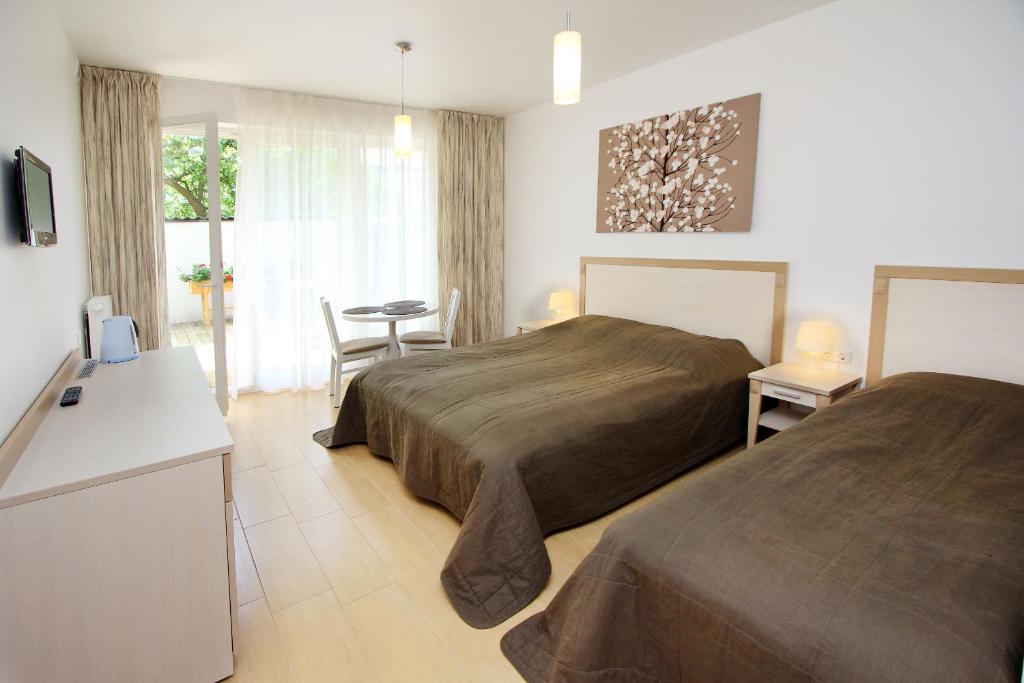 帕兰加多米诺别墅旅馆的酒店客房设有两张床和一张桌子。