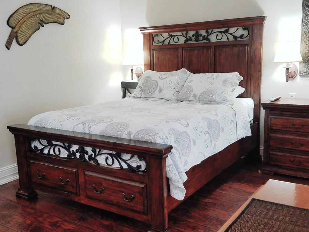 洛思加图斯Los Gatos Garden Inn Hotel的一间卧室配有一张大床和木制床头板