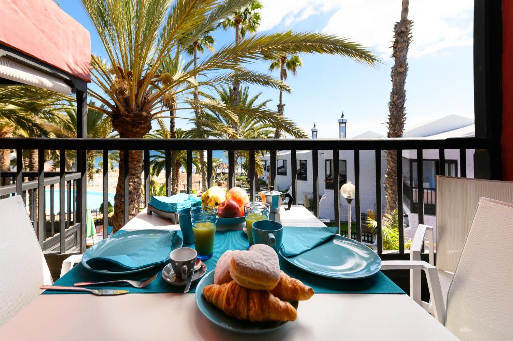 圣巴托洛梅Luxury Bungalow Seaview - Sun Club Maspalomas的棕榈树阳台的餐桌