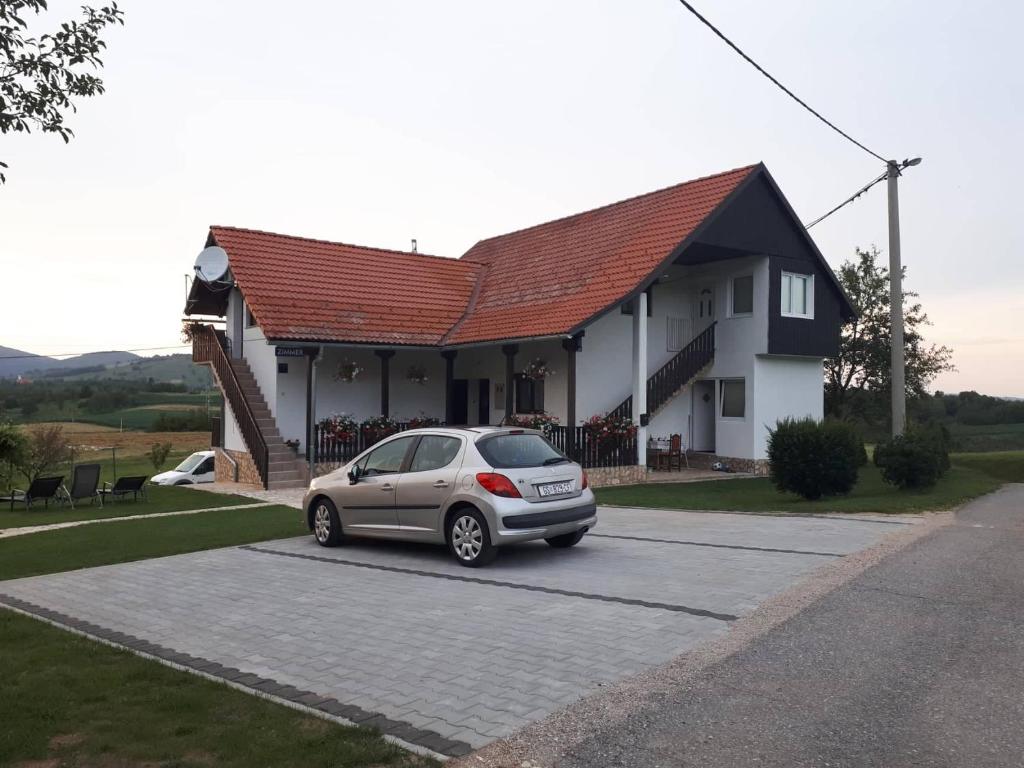 斯莫利亚纳茨安德亚酒店的停在房子前面的停车场的汽车