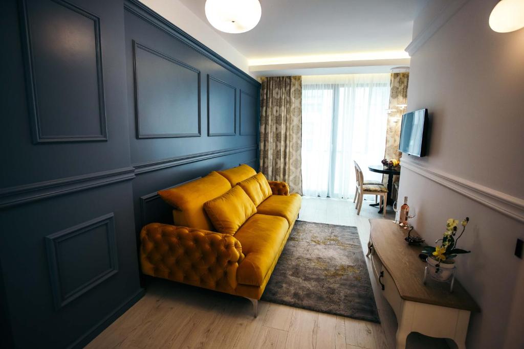 克卢日-纳波卡Briana Luxury Studio的客厅配有黄色的沙发和桌子