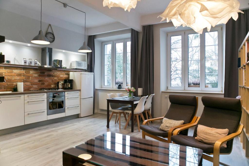 克拉科夫Cichy apartament w centrum Krakowa Salwator的厨房以及带桌椅的起居室。