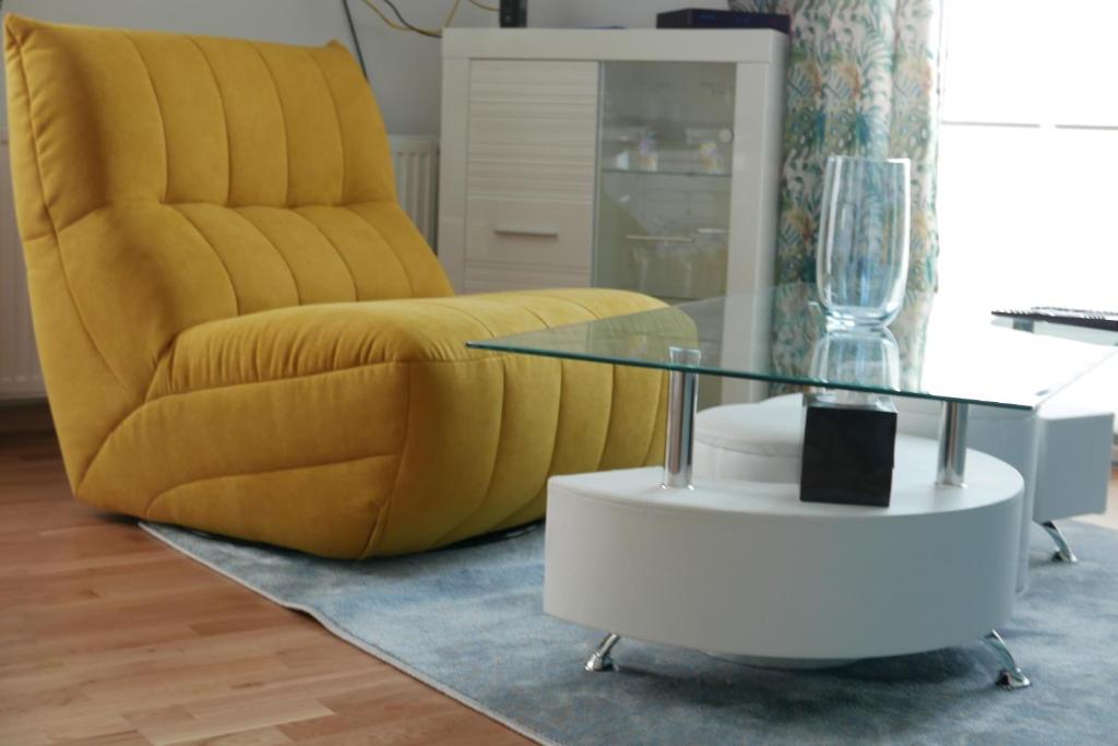 比亚瓦波德拉斯卡Apartament Soft 14的客厅配有黄色椅子和玻璃桌