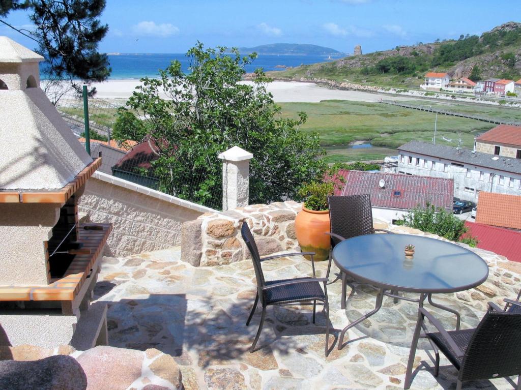 O PindoApts Playa Monte Pindo的一个带桌椅的庭院和大海