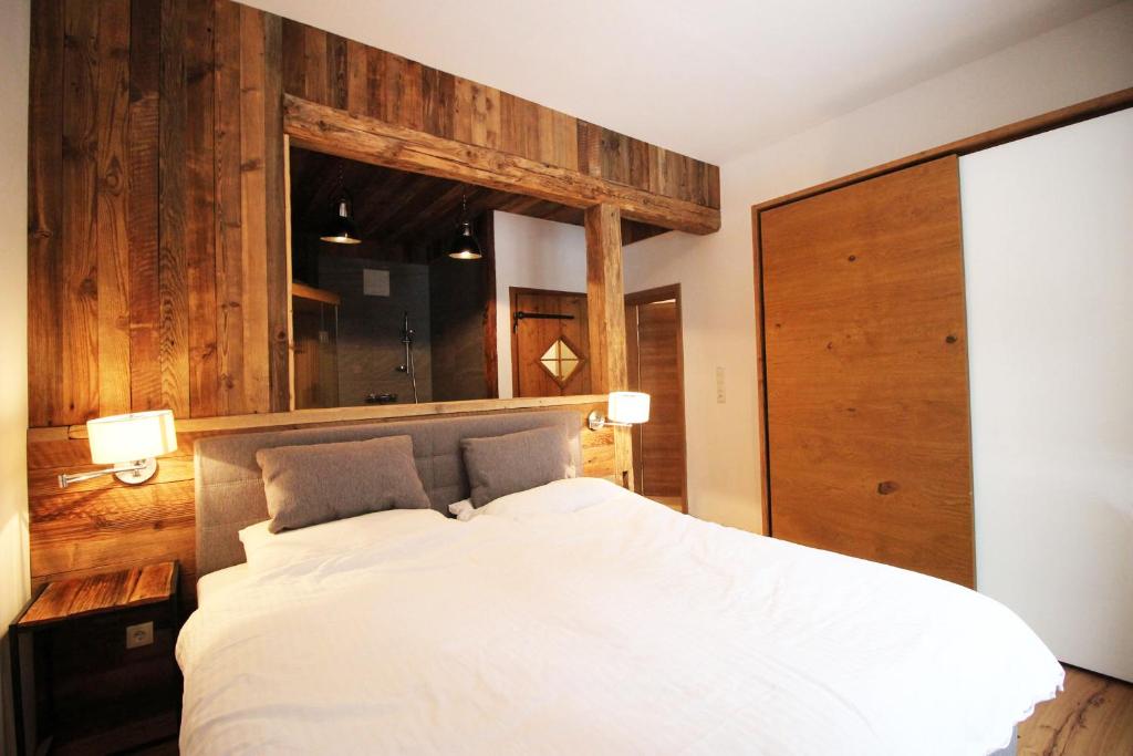 穆劳Alpengasthof Krische的卧室配有白色的床和木墙