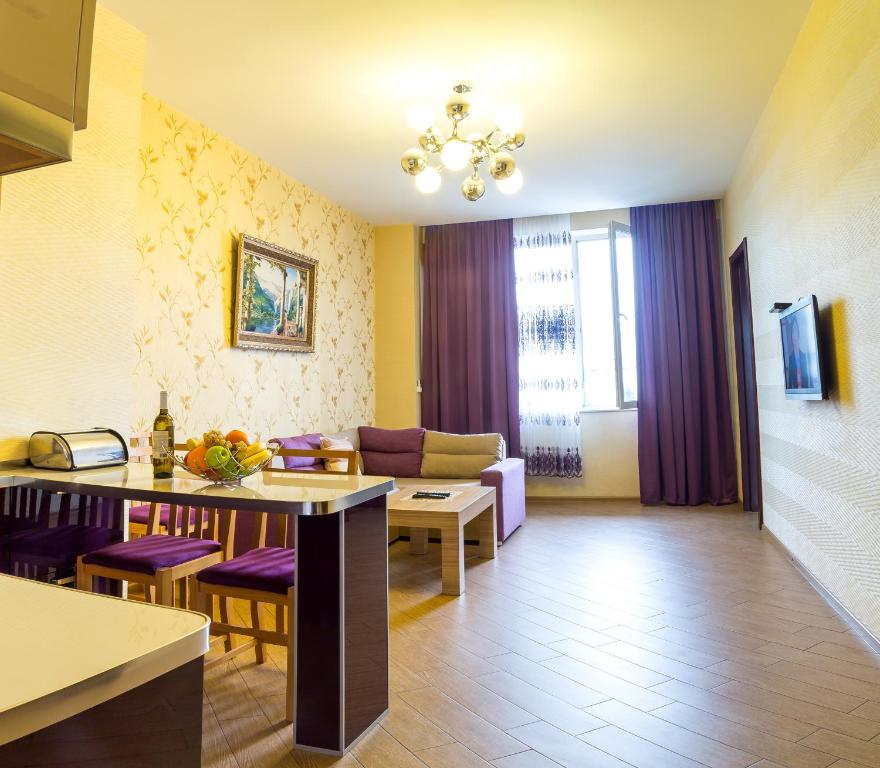 第比利斯Tbilisi Comfort Apartment的厨房以及带桌椅的起居室。