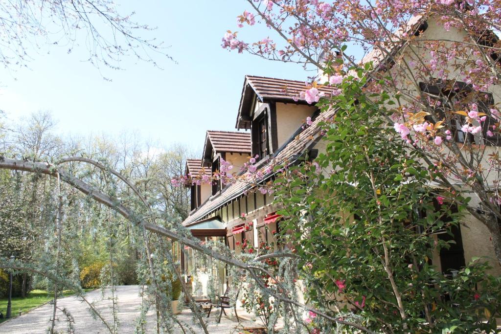 拉莫特－伯夫龙乐布利耶维酒店的一座建筑的侧面是粉红色的花朵