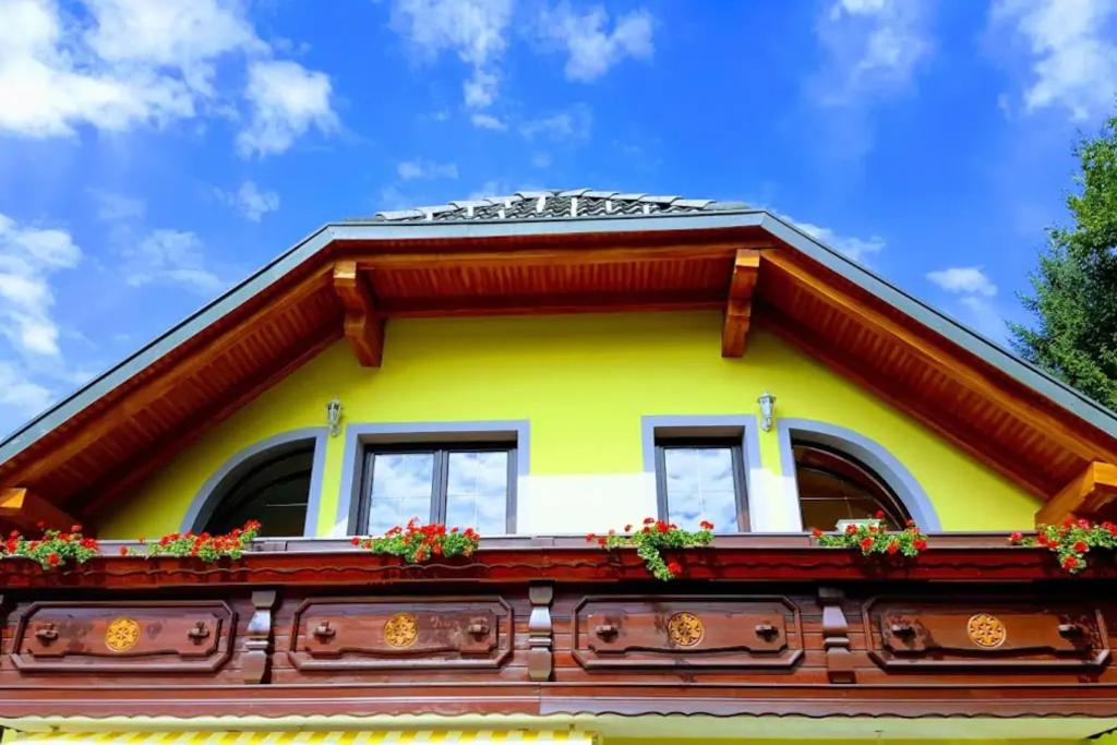 贝古耶·纳·格伦奇克Rooms Močilnik的黄色的房子,窗户和鲜花