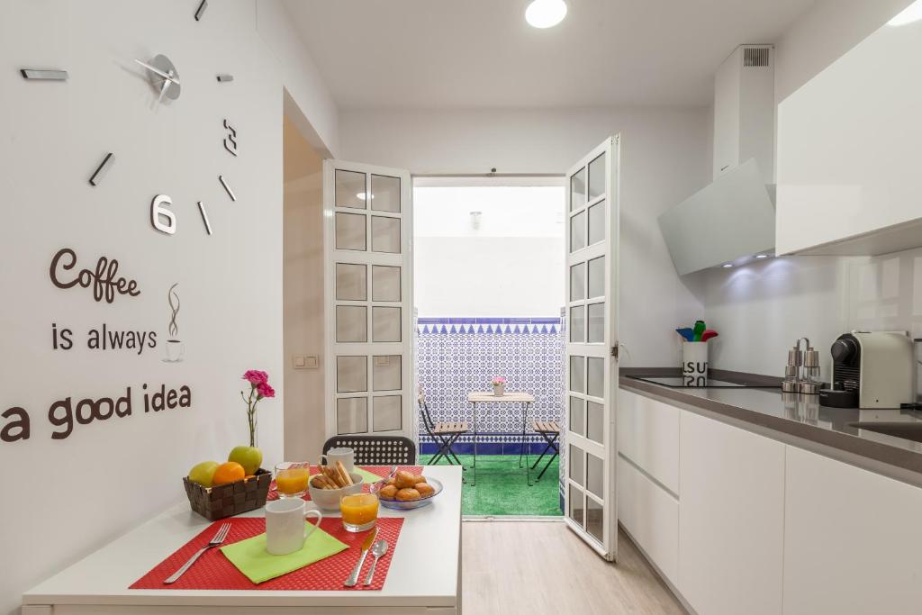 塞维利亚Casa de la Moneda - Center Luxury Duplex的白色的厨房,配有带水果的桌子